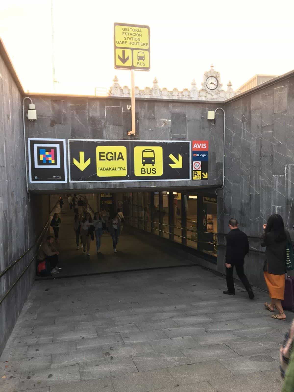 Personas bajando por la rampa de acceso a la estación subterránea de Donostia bajo el código NaviLens