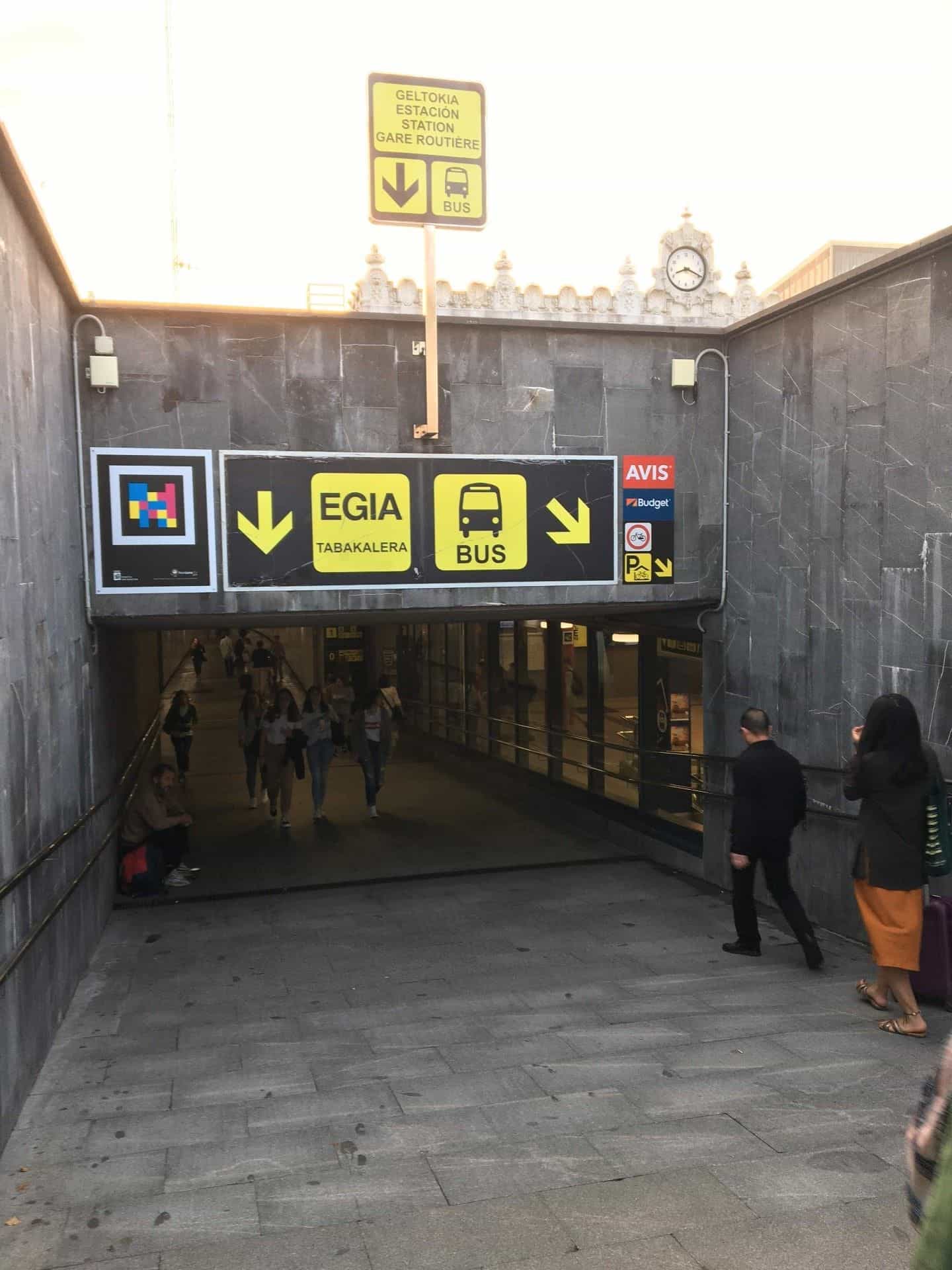 Persone che scendono lungo la rampa d’accesso alla stazione sotterranea di Donostia sotto il codice NaviLens