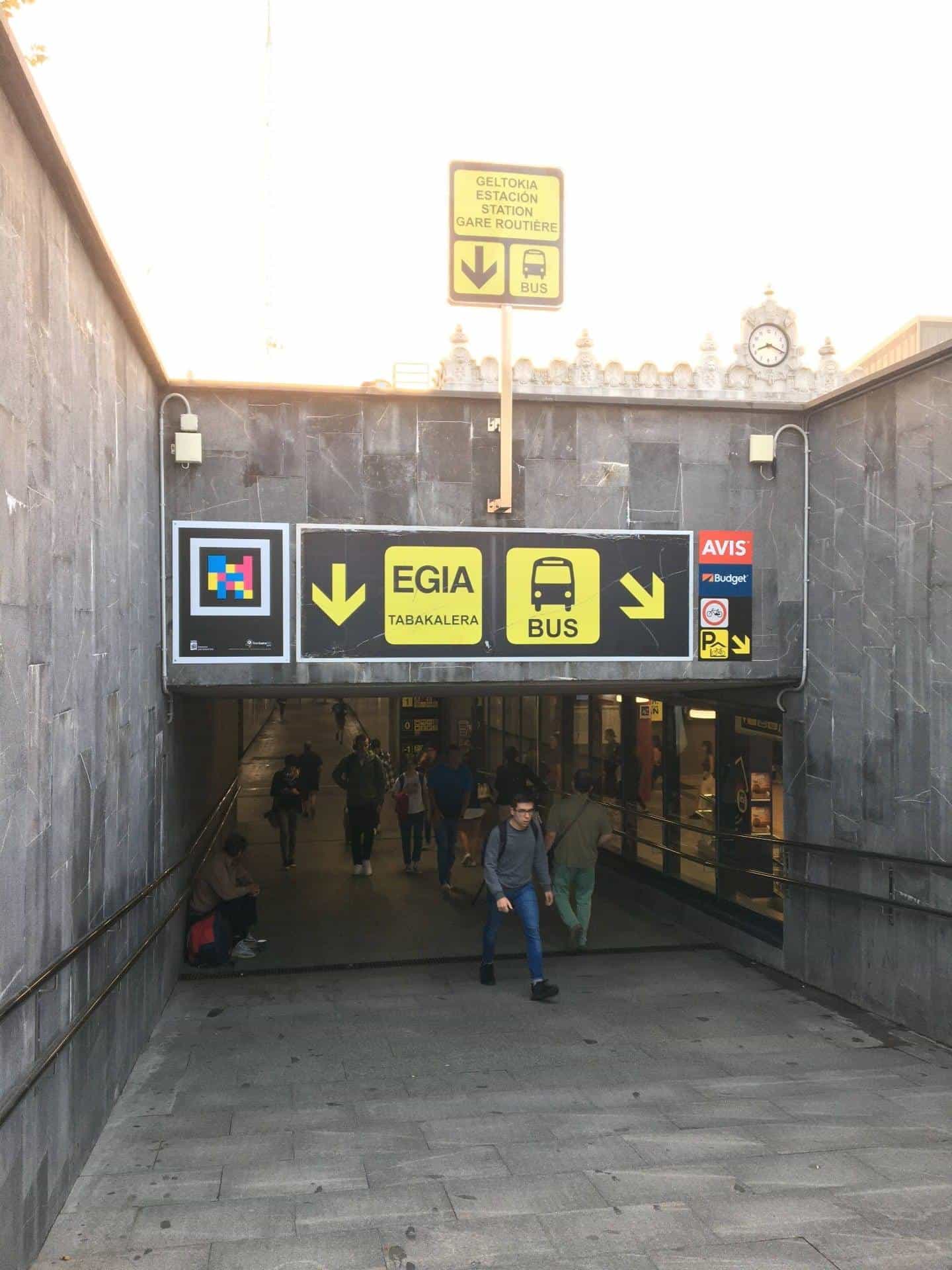 Pedestrian entrance to Donostia bus station with a NaviLens sign next to the yellow Egia, Tabakalera and Bus arrows