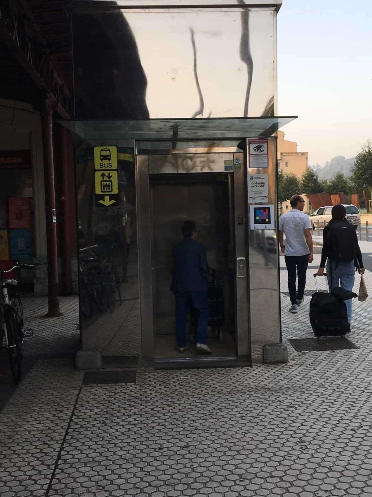 Cabina del ascensor exterior con cartel BUS y código NaviLens junto al horario Igogailua / Ascensor 6:00–24:00