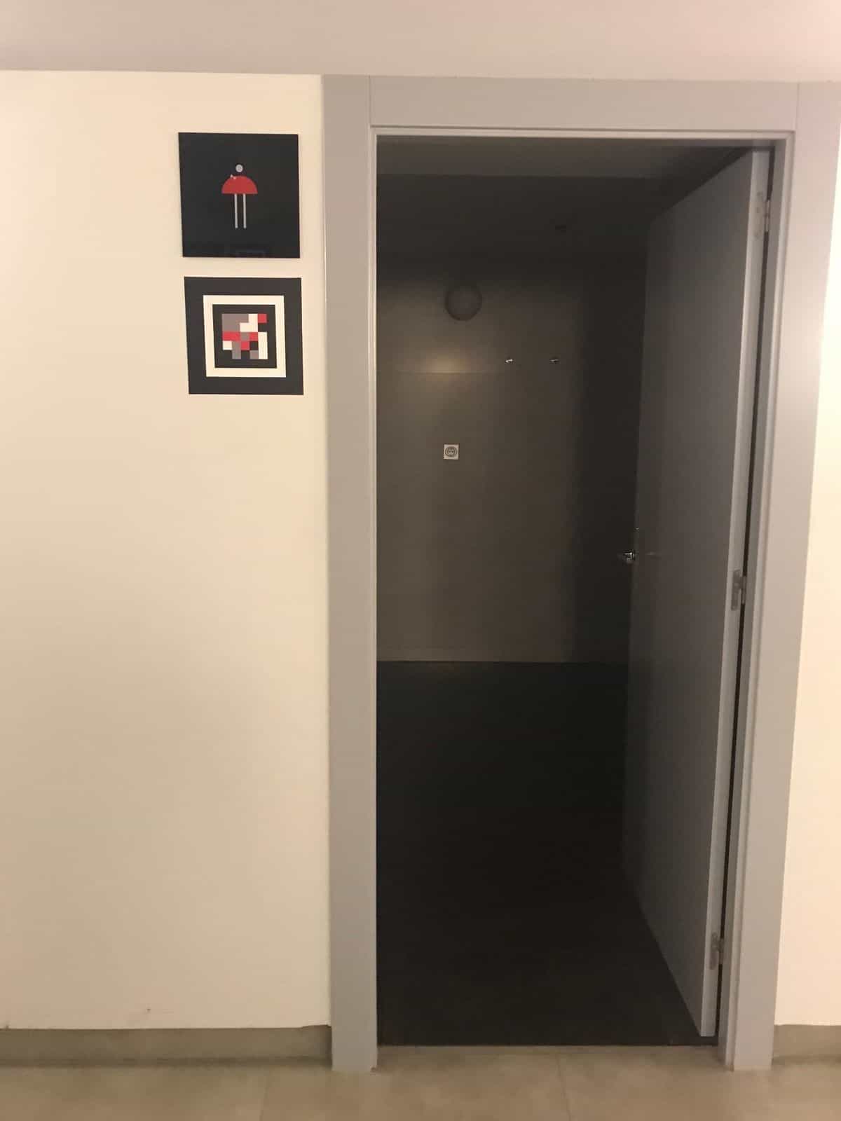 Acceso a los aseos del Teatro Circo con pictograma y código NaviLens en la pared