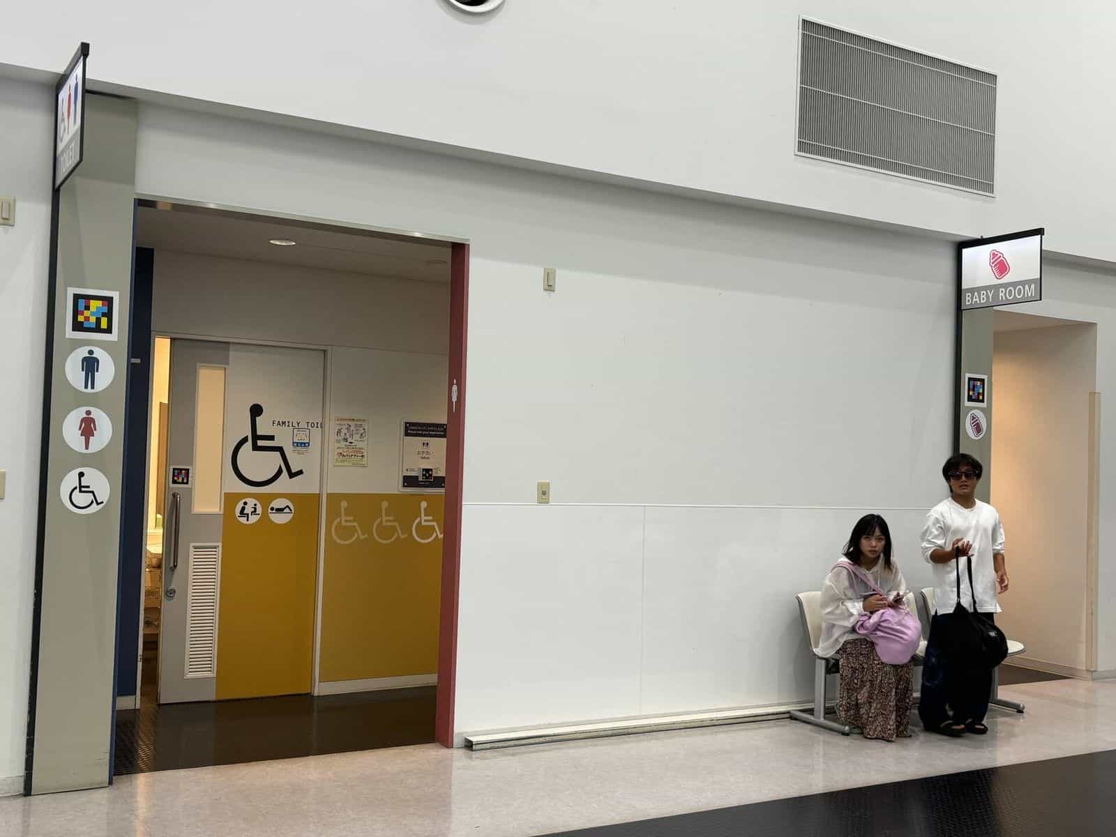 Vorraum im Kobe Airport mit «TOILET»-Schild und Mann-, Frau- und Rollstuhl-Piktogrammen, alle mit NaviLens-Tag