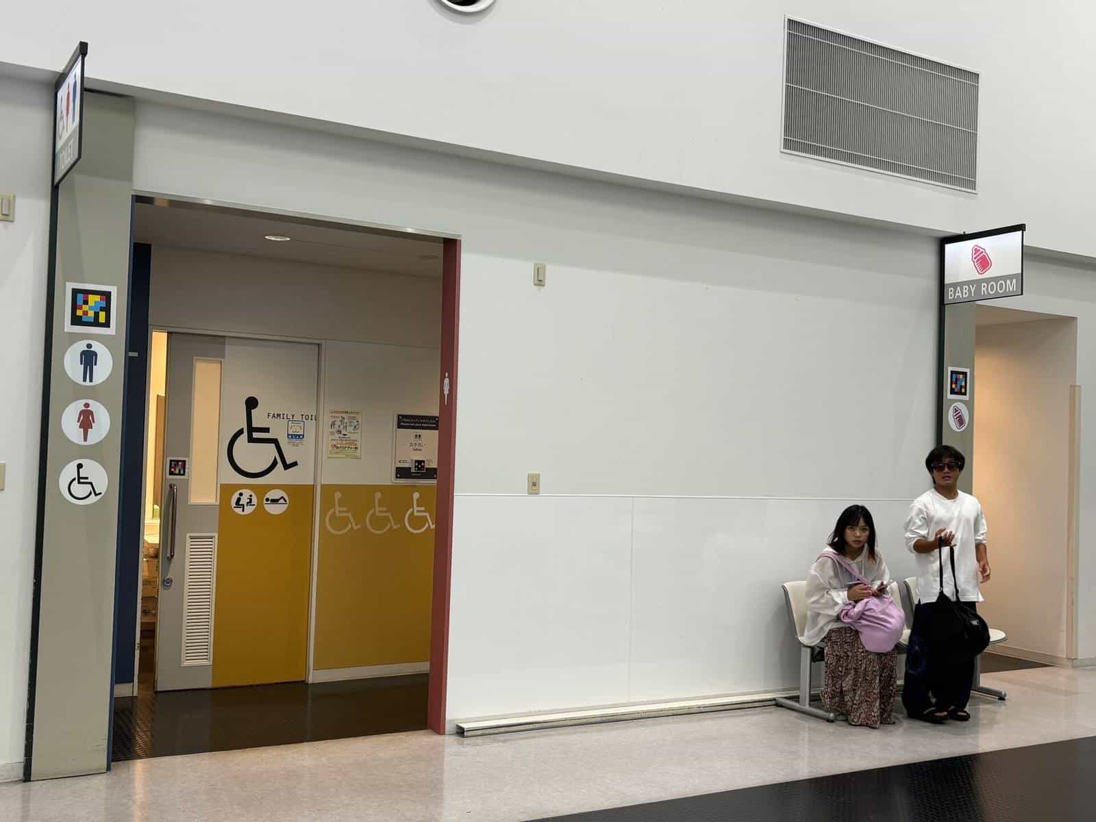 Lobby at Kobe Airport with “TOILET” sign and man, woman and wheelchair pictograms, all paired with NaviLens tags