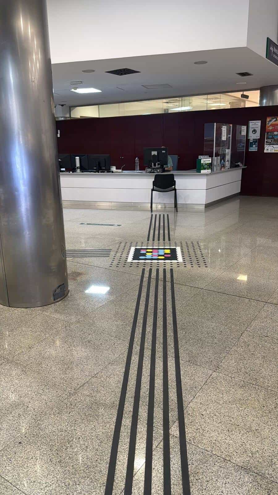Adif Customer Service desk with tactile strips and a large NaviLens code printed on the floor