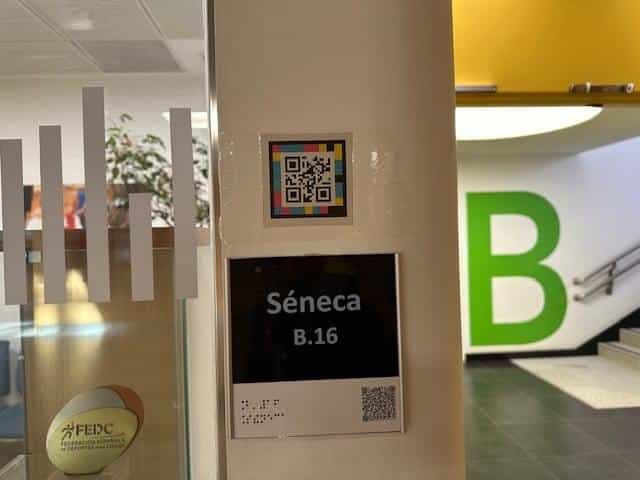 Classroom Séneca B16 at CRE ONCE Madrid with braille label, large number and NaviLens marker on the wall
