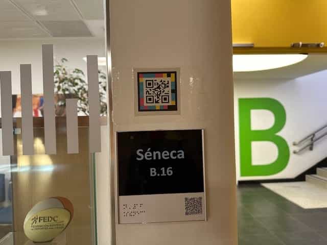 Aula Séneca B16 del CRE ONCE Madrid con cartela braille, número grande y código NaviLens en la pared