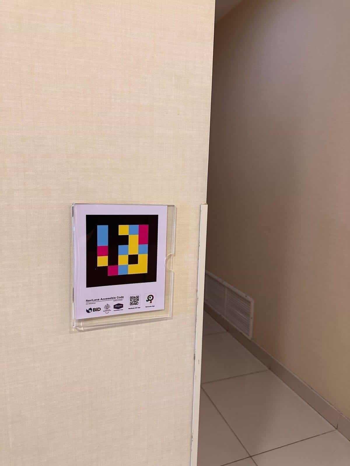 NaviLens sign in the corridor leading to the toilets at the Hampton by Hilton