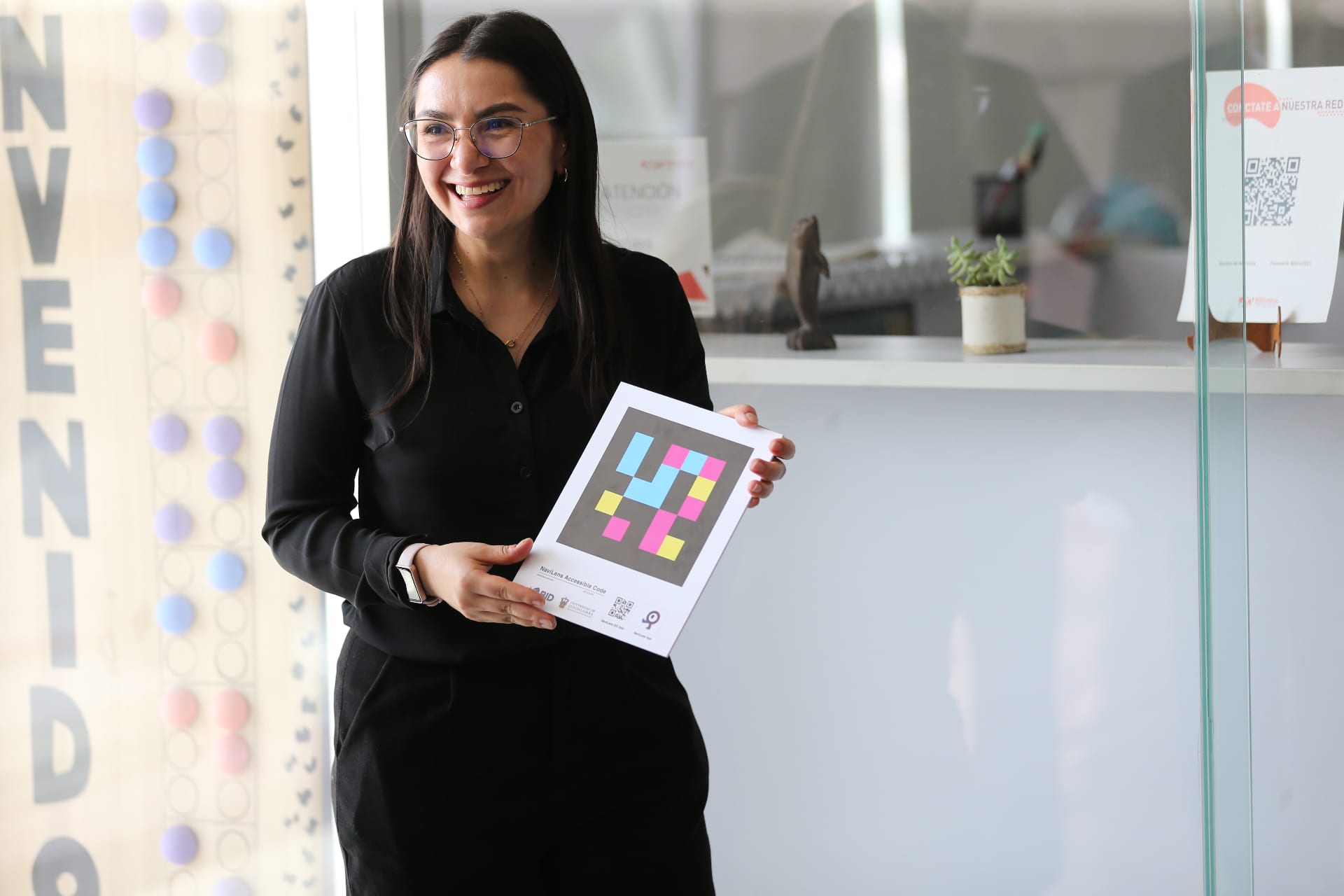 A librarian holds a card with a NaviLens code co-funded by the IDB and the University of Guadalajara, at the BPEJ Juan José Arreola