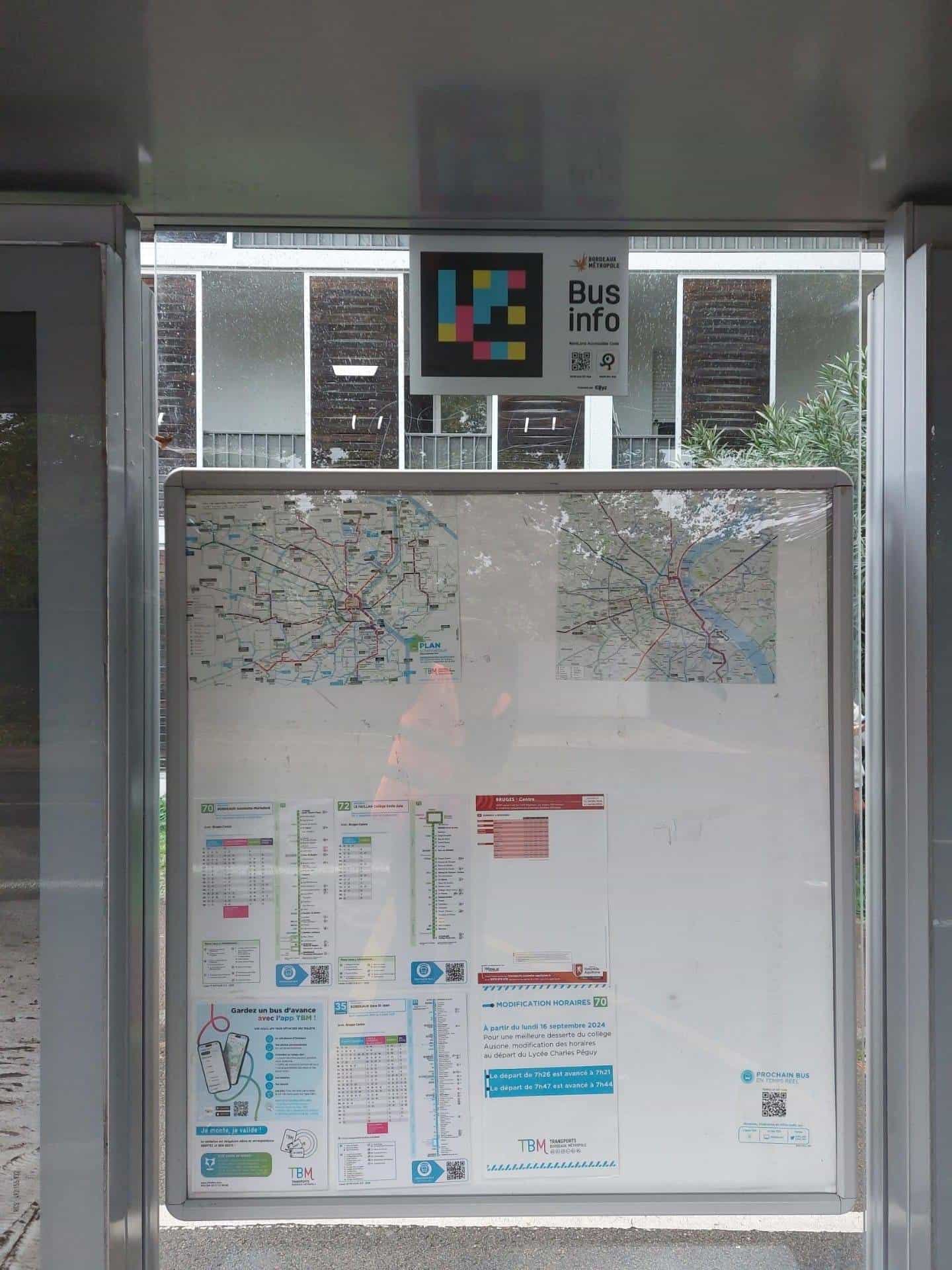 “Bus info — NaviLens Accessible Code” panel with the coloured code installed above the network map inside a TBM shelter at Bruges Centre