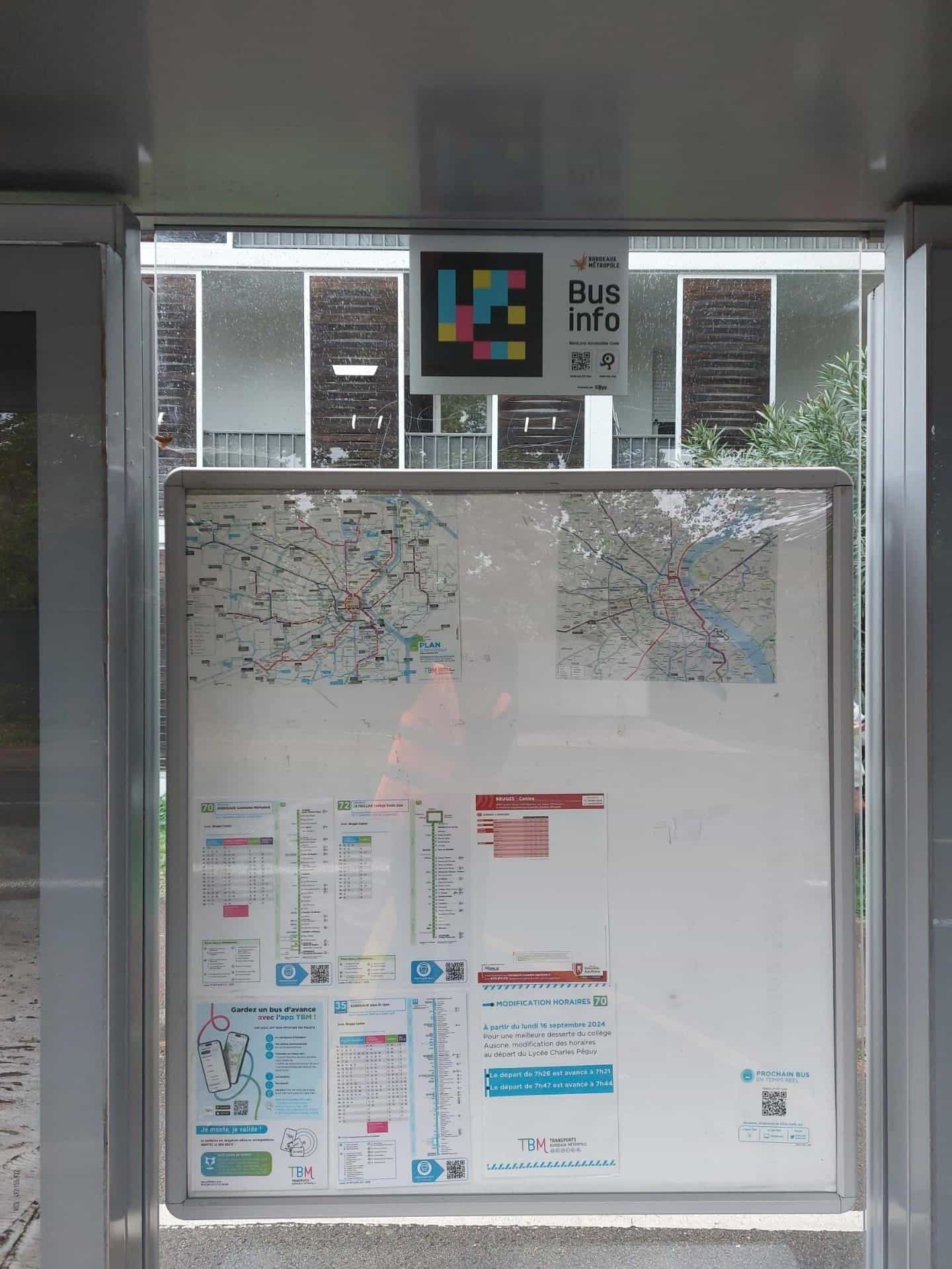Bruges CentreのTBMシェルター内、ネットワーク図の上に設置された「Bus info — NaviLens Accessible Code」パネルと色付きコード