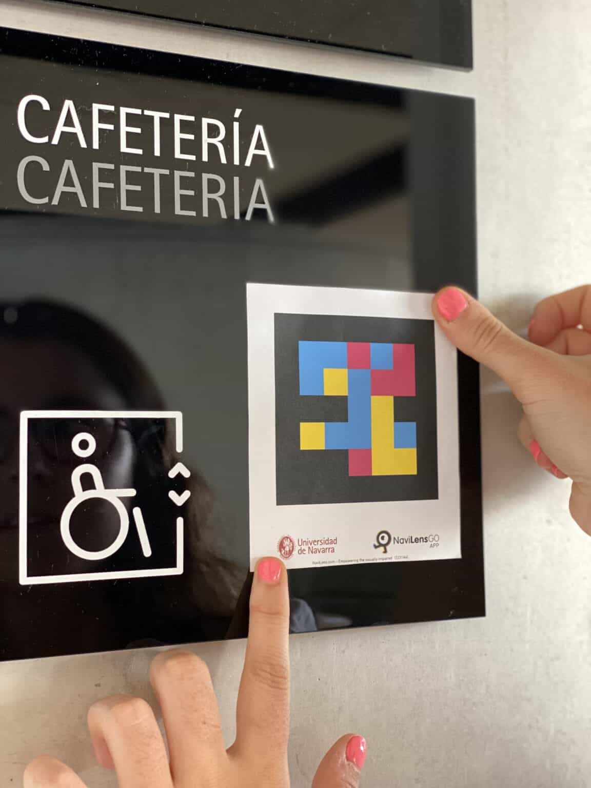 Cafetería del campus de la UNAV con código NaviLens en la mano de un usuario