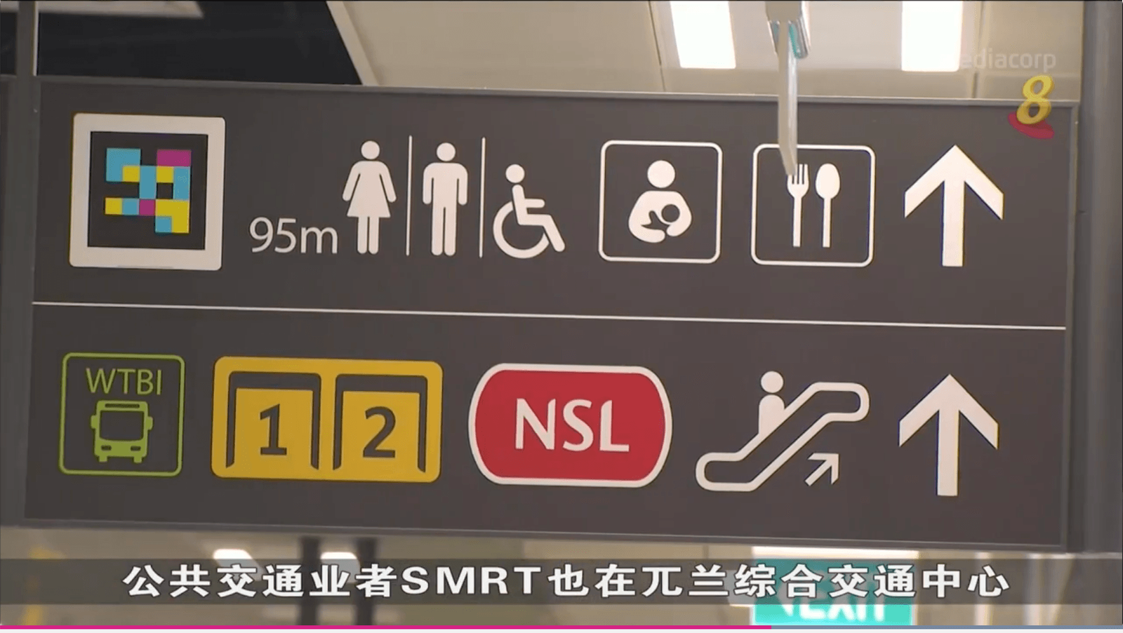 Grey wayfinding sign with NaviLens code, “95 m” and pictograms for toilets, NSL and bays 1-2