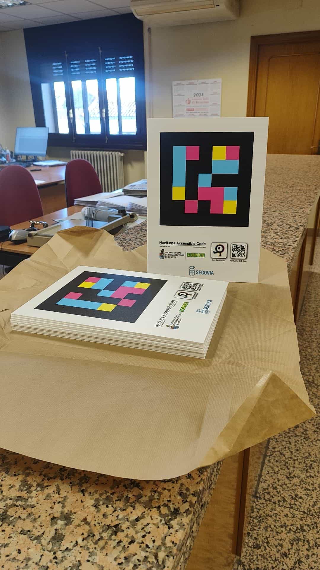 Nahaufnahme eines NaviLens-Schilds der COF Segovia mit Farbcode und Download-QRs