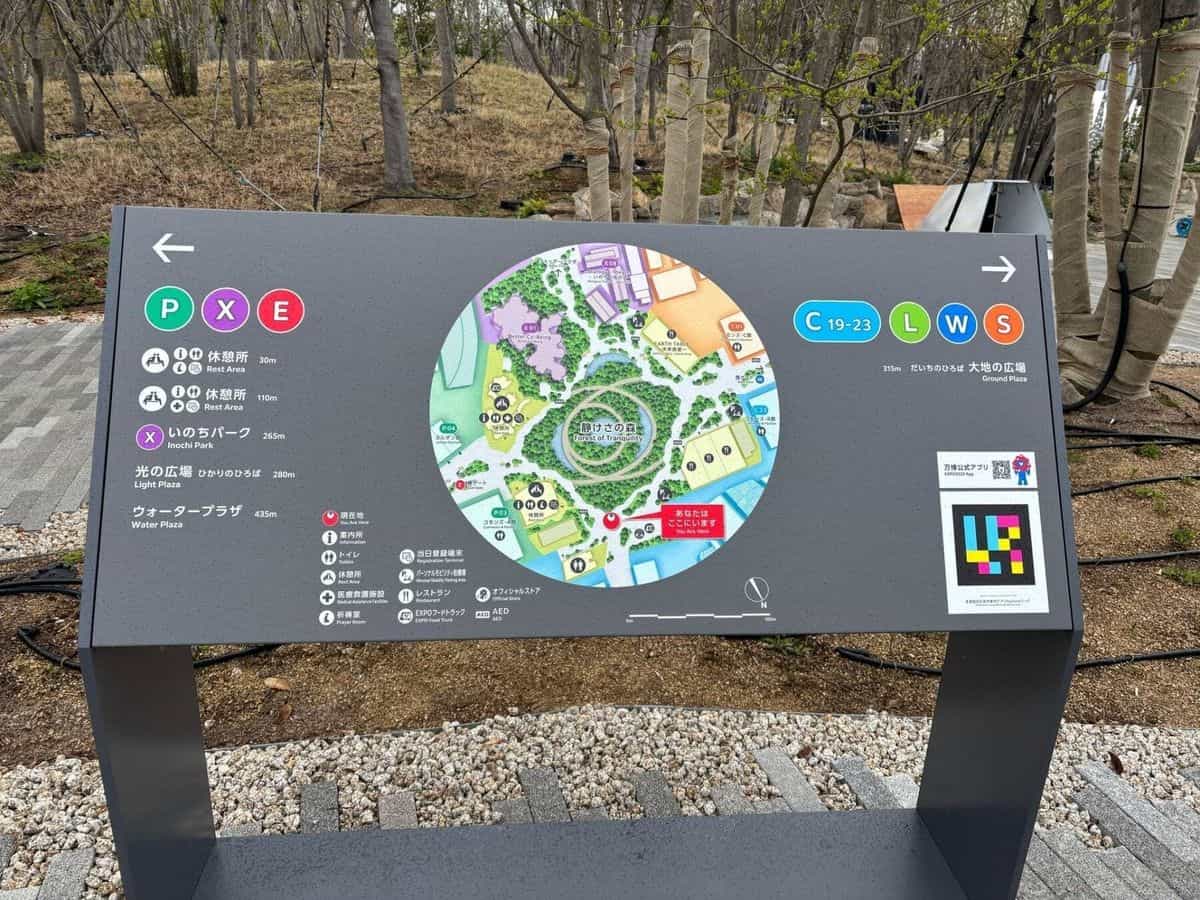 万博2025会場の円形マップ「静けさの森 / Forest of Tranquility」、P・X・E・C・L・W・Sゾーンのアイコン、右下にシアン・マゼンタ・イエローのNaviLensコード