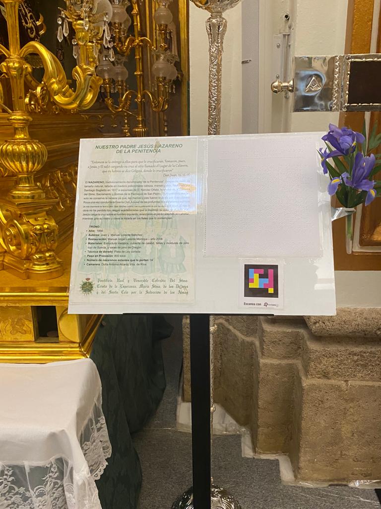Lectern with the accessible caption of «Our Father Jesus Nazarene of Penitence» and NaviLens code