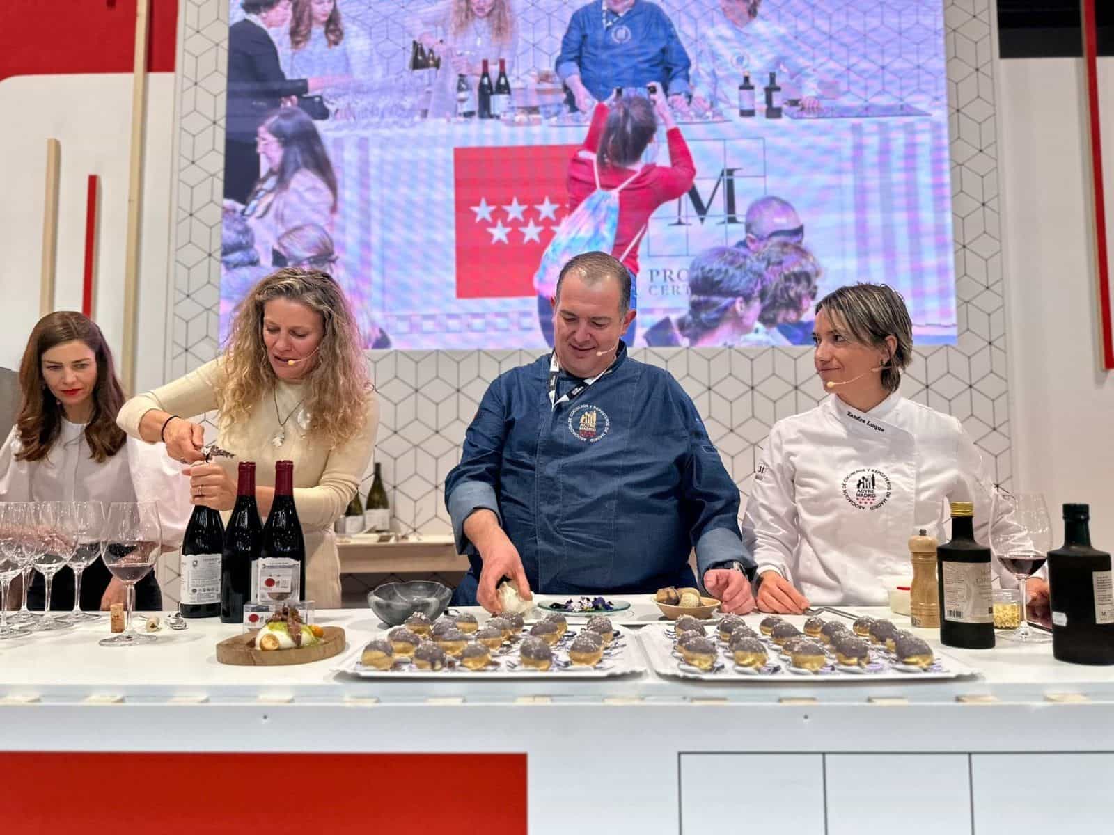 Le chef di ACYRE Madrid e l’enologa di Las Moradas de San Martín preparano tapas e stappano vini della DOP Vinos de Madrid su un bancone bianco con i calici allineati, durante la degustazione «Activa tus Sentidos» di Decanta Madrid
