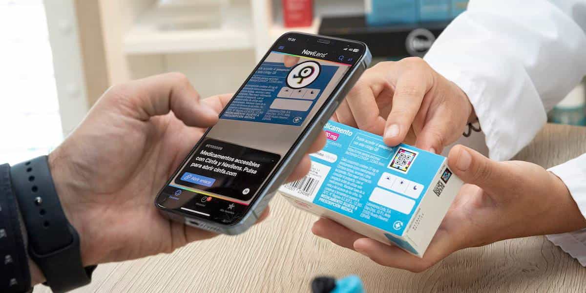 Illustration of a Cinfa medicine carton with a NaviLens code and a hand holding a smartphone running the NaviLens GO app.