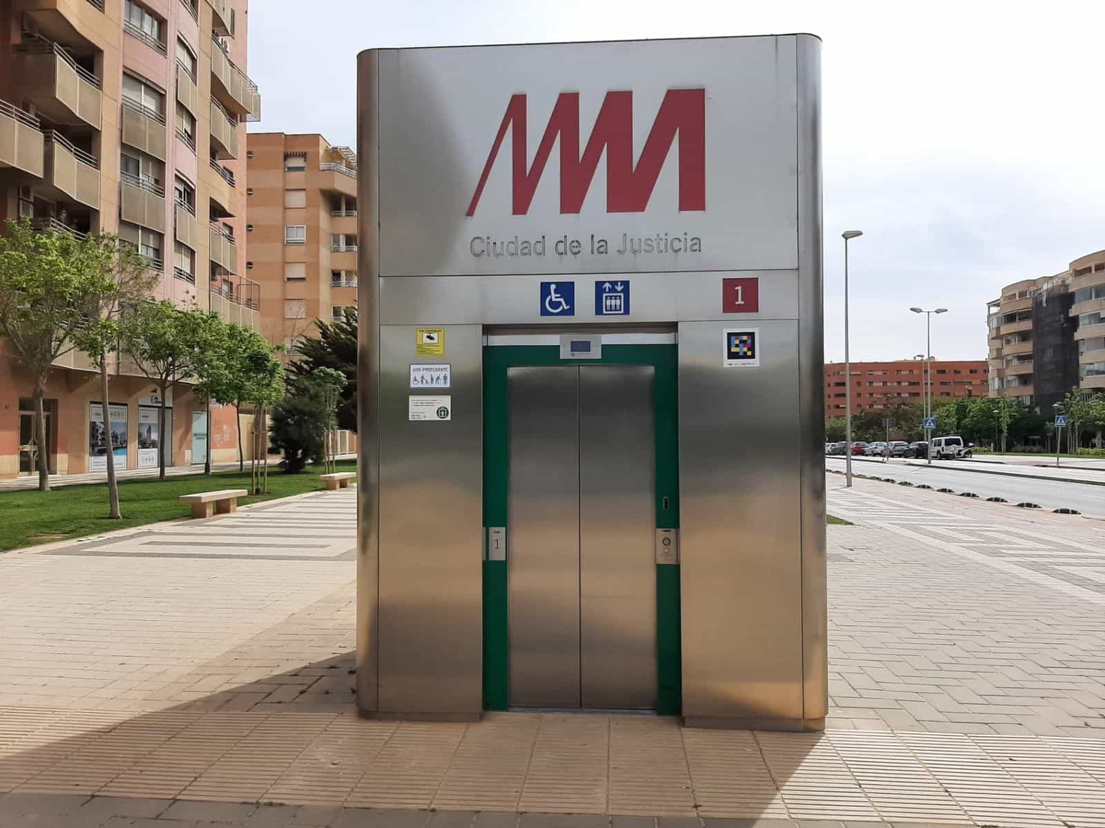 Ascensore su strada del Metro de Málaga a «Ciudad de la Justicia» con la M rossa e codice NaviLens accanto al pittogramma di uso preferenziale