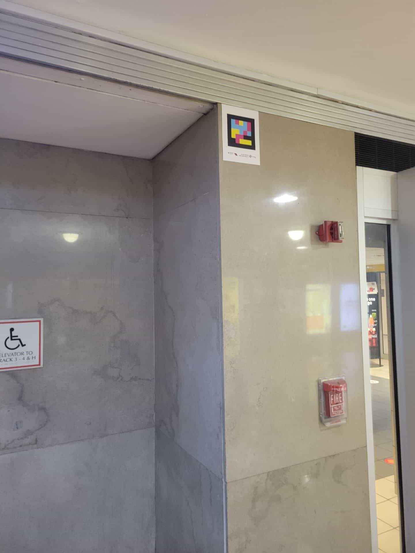 NaviLens code installed high above the corridor of elevators to tracks 3-4 and H inside Newark Penn Station