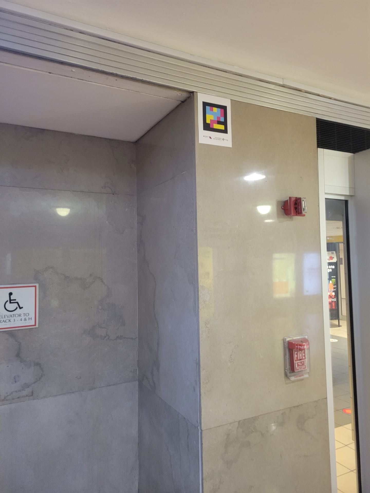 NaviLens code installed high above the corridor of elevators to tracks 3-4 and H inside Newark Penn Station