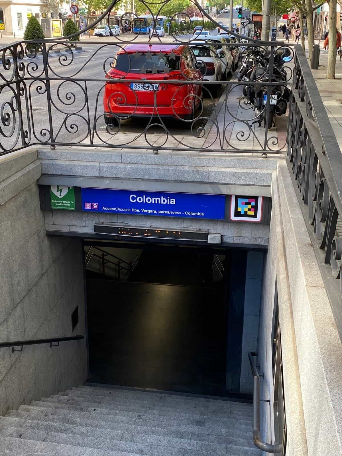 Acceso a la escalera de Colombia (L8 Metro de Madrid) con cartel y código NaviLens