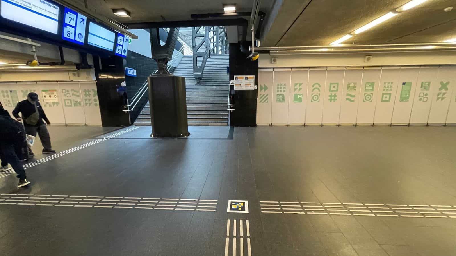 Zugang zu den Treppen der Bahnsteige 7 und 8 in Amsterdam Centraal mit Leitlinien und NaviLens-Code im Boden