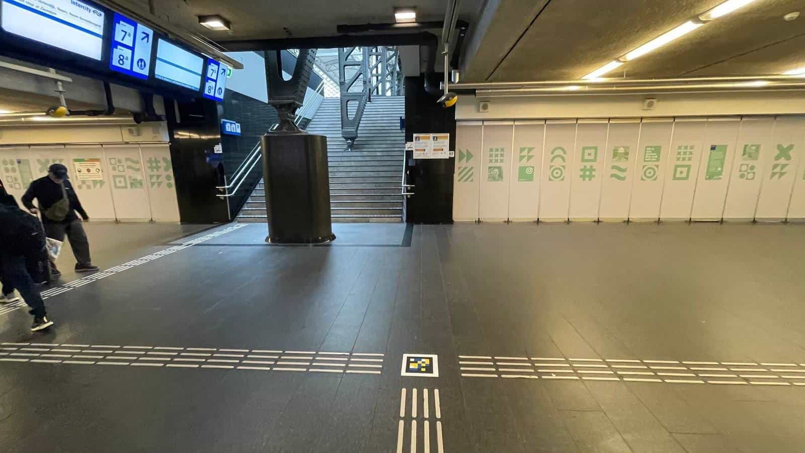Access to the stairs of platforms 7 and 8 at Amsterdam Centraal with guide lines and a NaviLens code on the floor