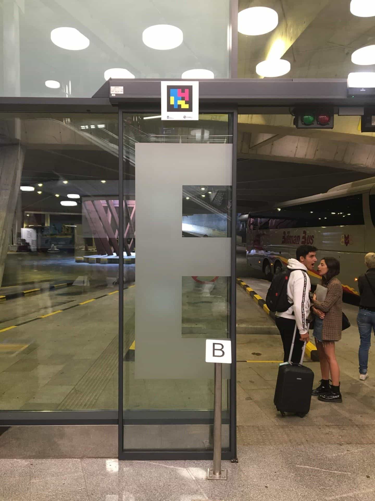 Targa bianca con la lettera B accanto alla porta a vetri dello stallo B con codice NaviLens sull’architrave