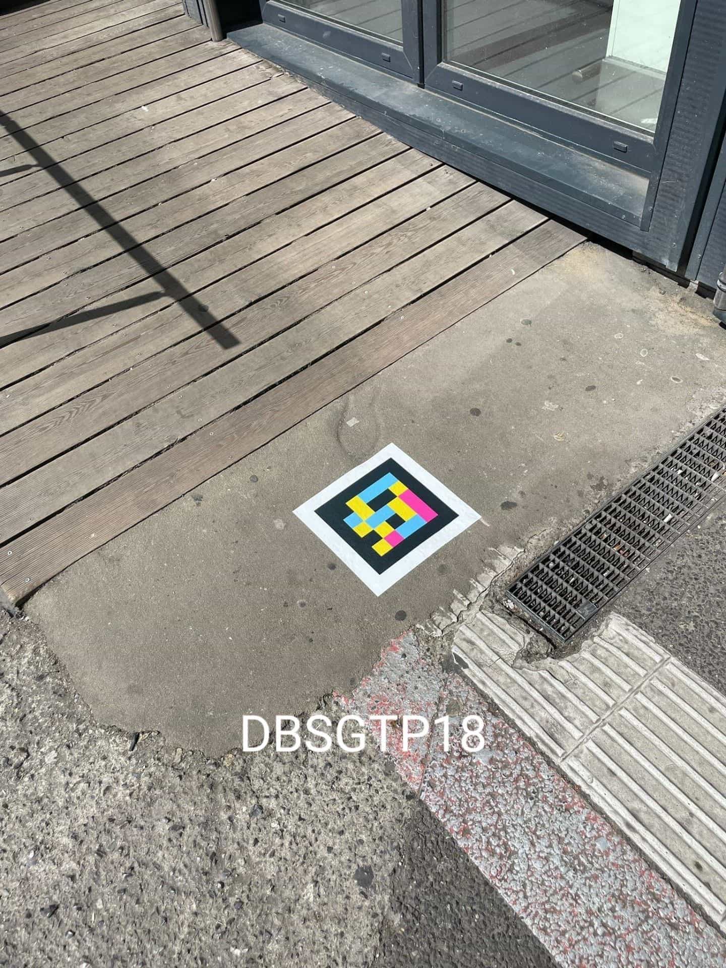 Accès à un local du Hbf : parquet en bois, bande podotactile et code NaviLens carré collé sur le béton poli (DBSGTP18)