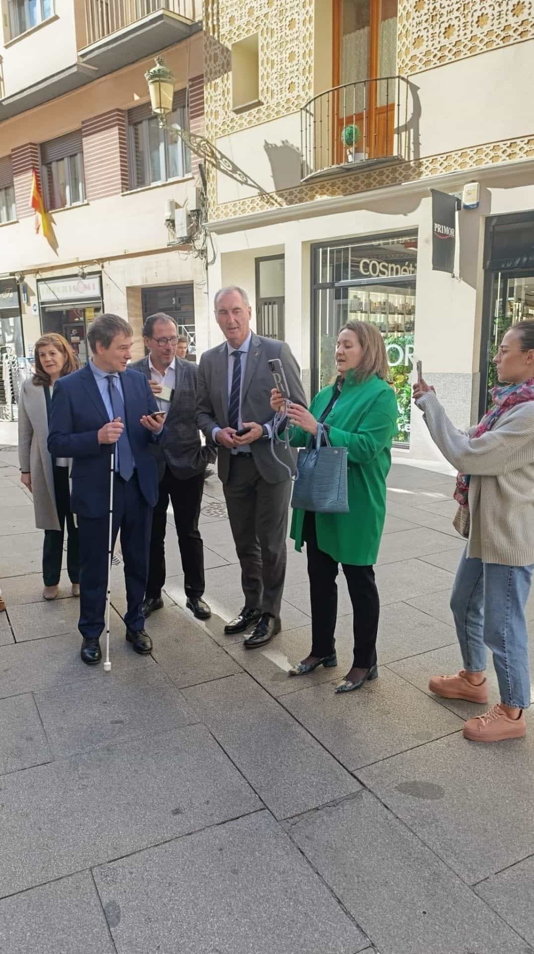 Demonstration in der Calle Juan Bravo, Segovia: Ein Mensch mit Blindenstock testet die NaviLens-App vor einer Apotheke
