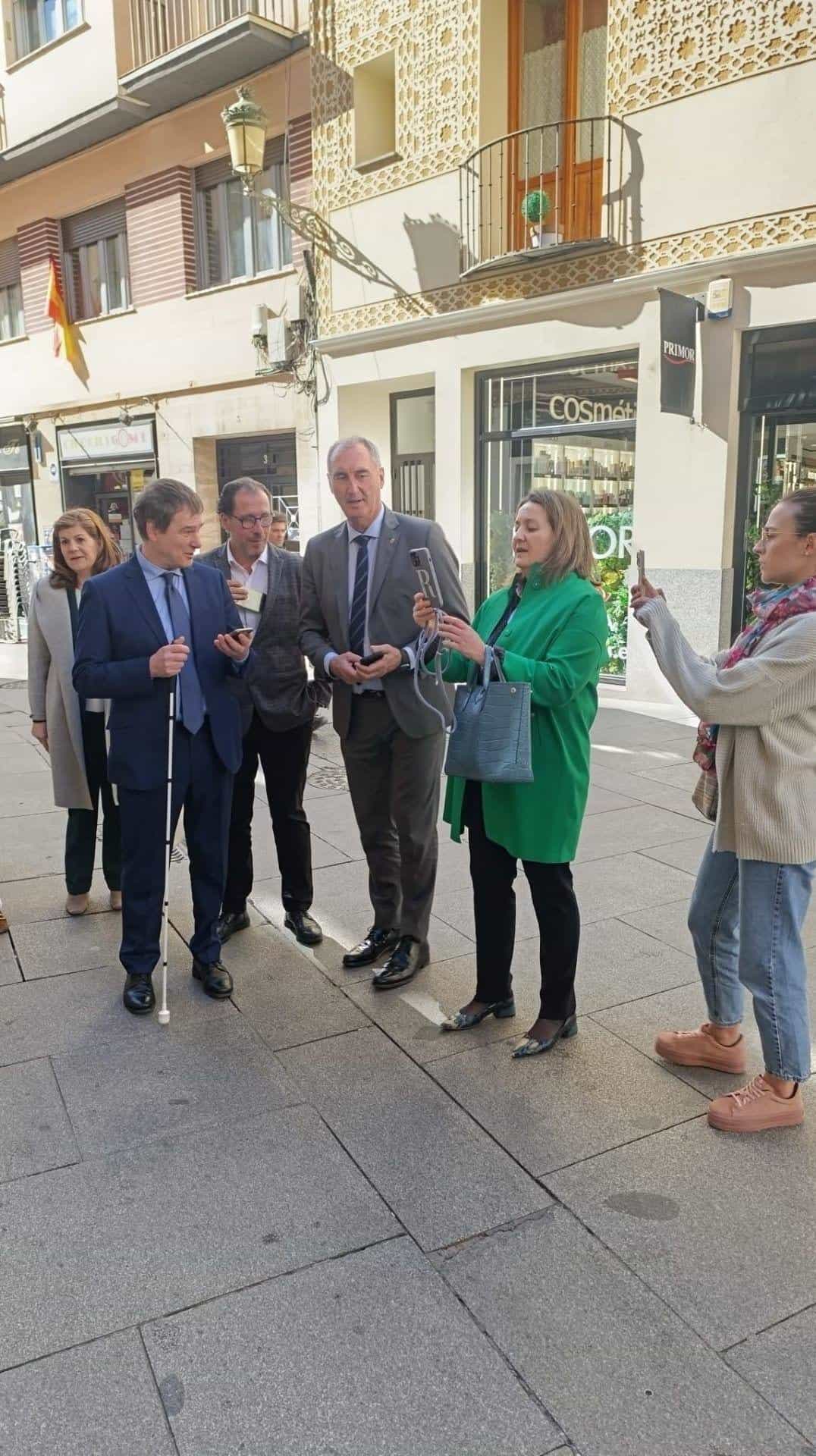 Street demonstration on Calle Juan Bravo, Segovia: a person with a white cane tries the NaviLens app in front of a pharmacy