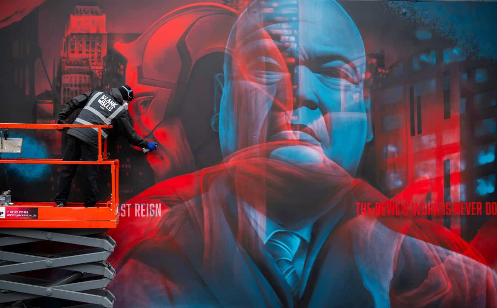 Close-up of the double-exposure mural: Daredevil in red and Kingpin in blue, overlaid on the Hell's Kitchen skyline