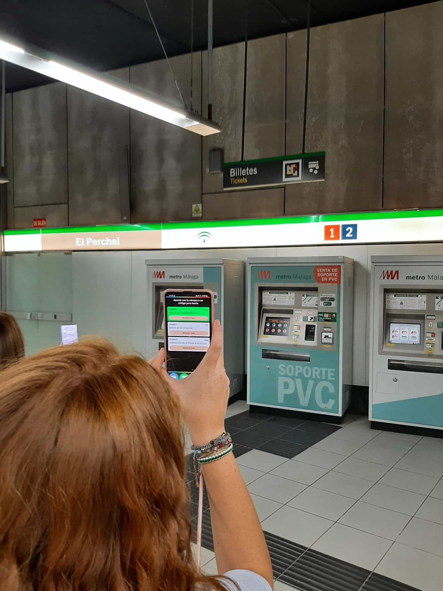 Estación El Perchel (Metro de Málaga): usuaria escaneando un código NaviLens en las máquinas de billetes