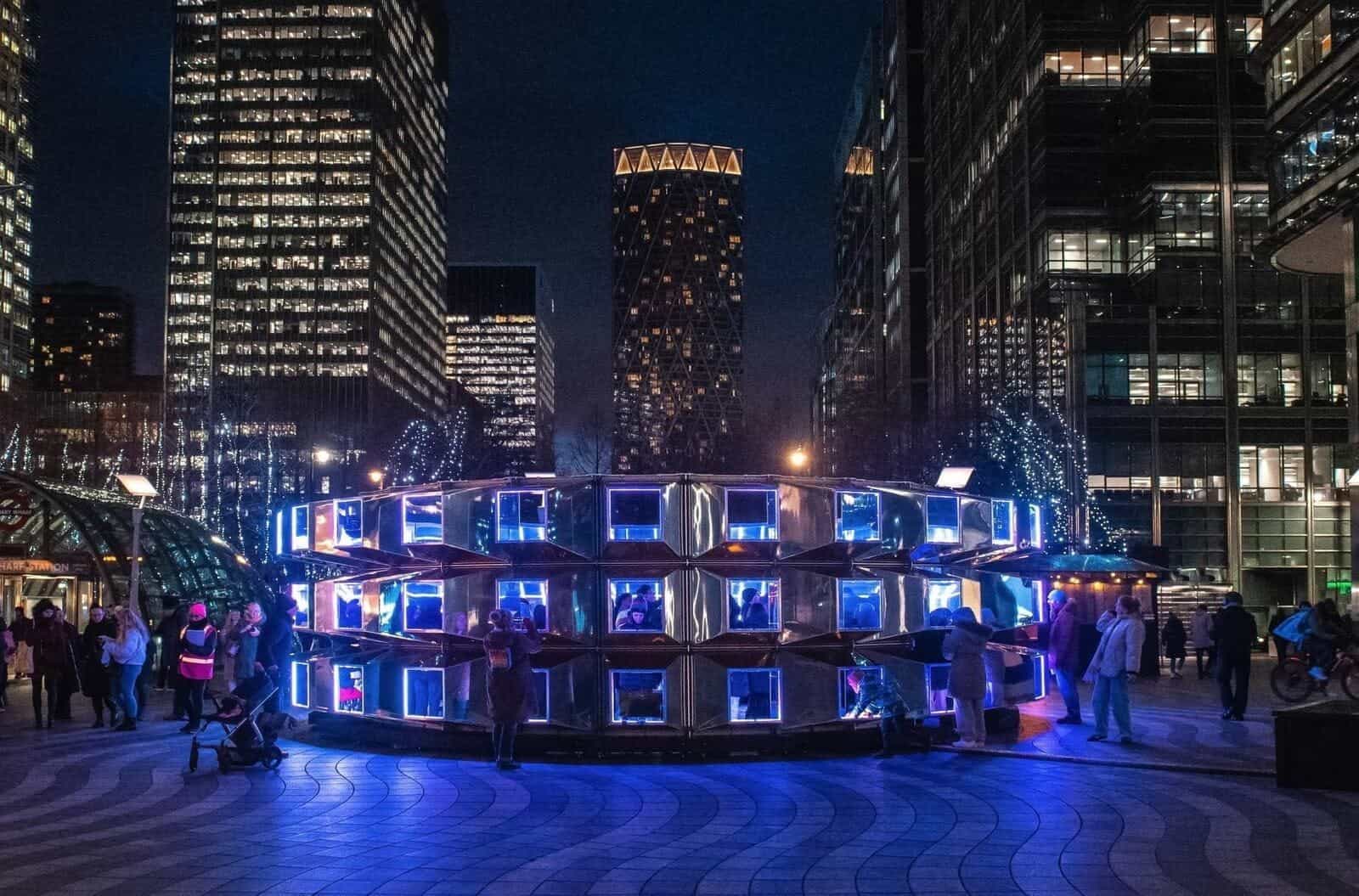 Installazione Emergence di This is Loop a The Circle (Leicester): cubi specchiati con LED azzurri e visitatori intorno