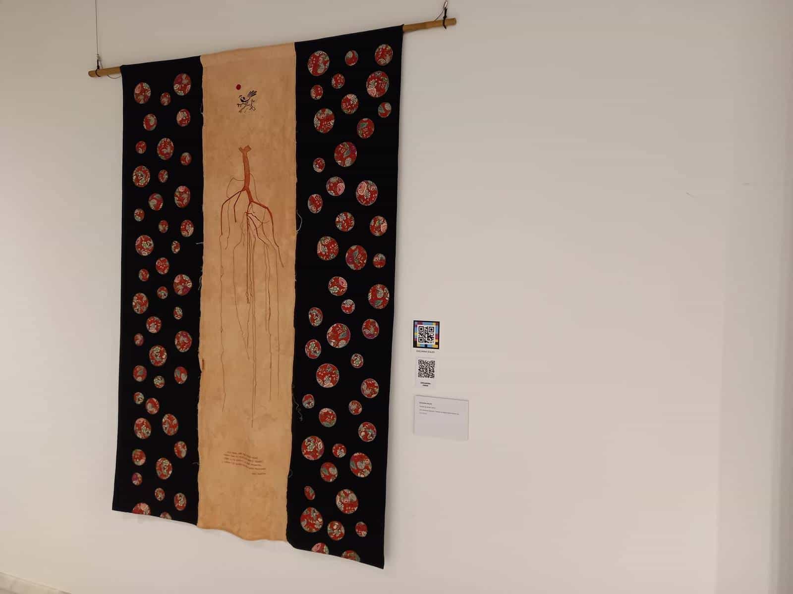 Textile tapestry by Encarna Soler with two NaviLens codes next to the label at the GAB hall in Benissa