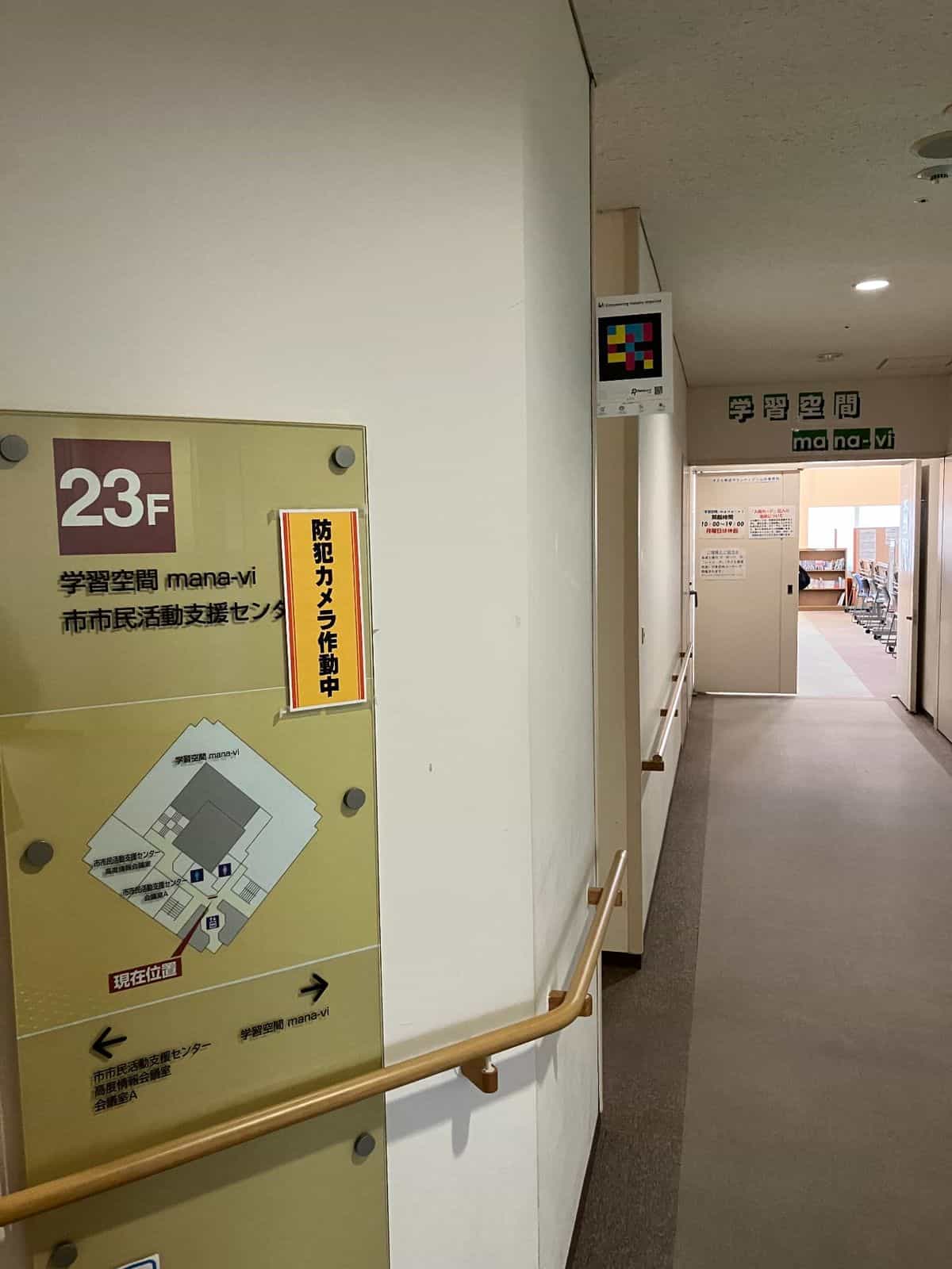 Access to the 23rd floor of the Yamagata City Civic Activity Support Center with the 学習空間 mana-vi sign and a NaviLens code on the column of the corridor