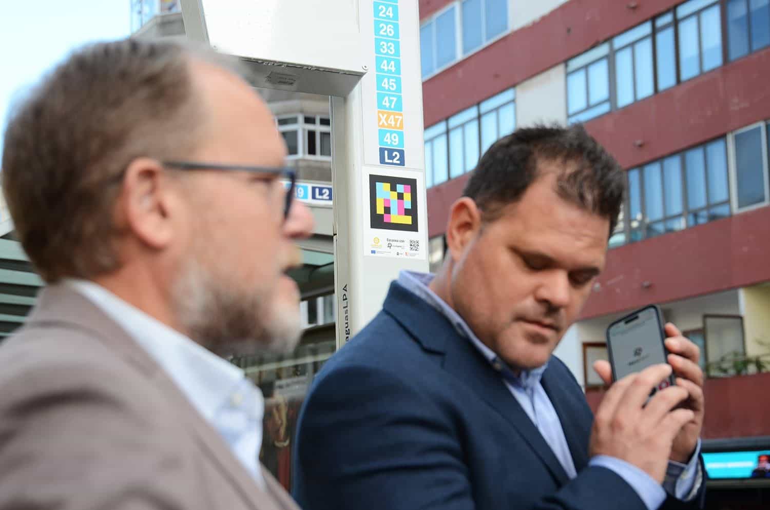 Scannen eines NaviLens-Codes am Pfosten einer Haltestelle von Guaguas Municipales mit den Linien 24, 26, 33, 44, 45, 47, X47, 49 und L2