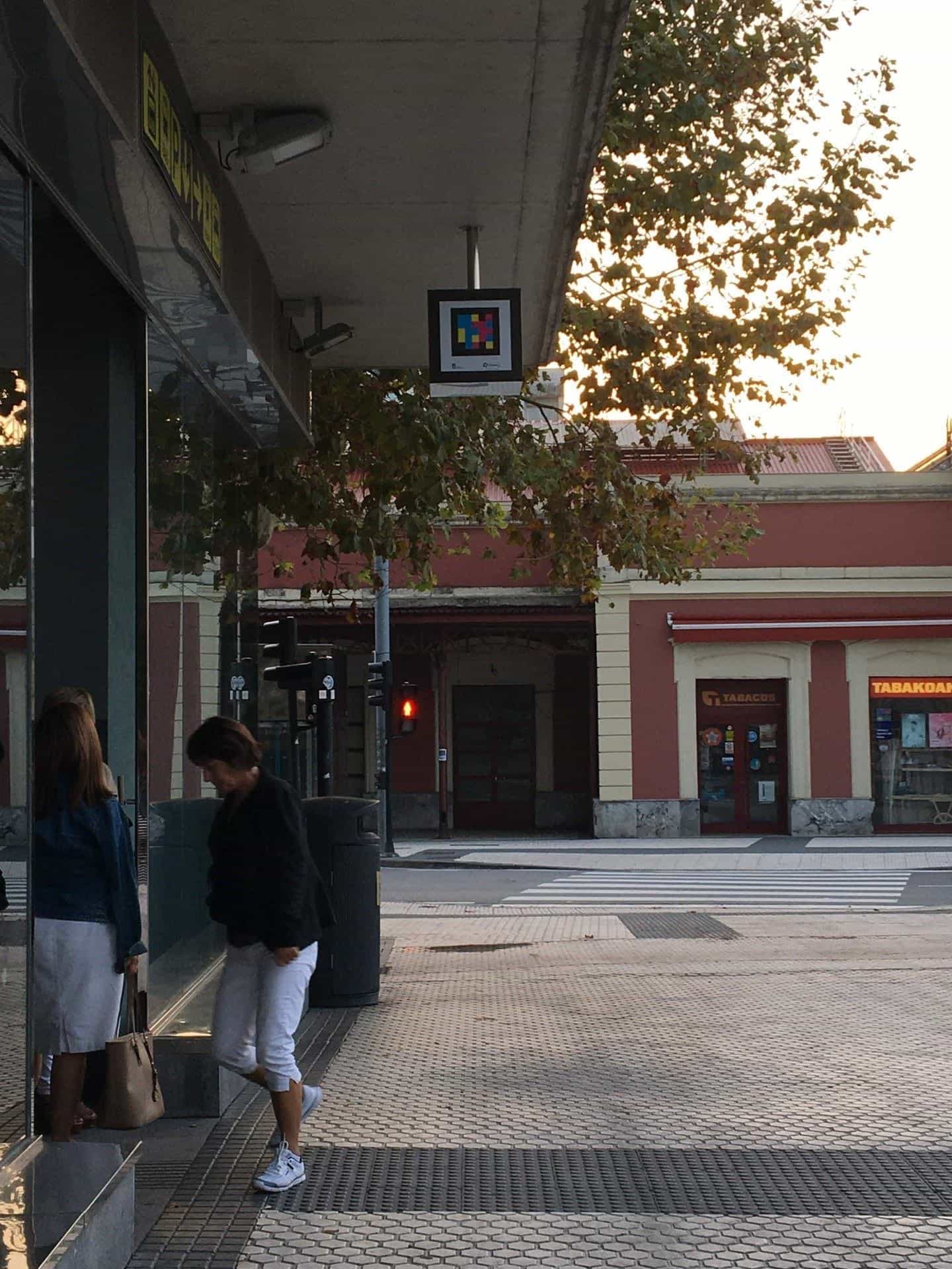Cartello NaviLens appeso al soffitto della pensilina esterna della stazione degli autobus di Donostia