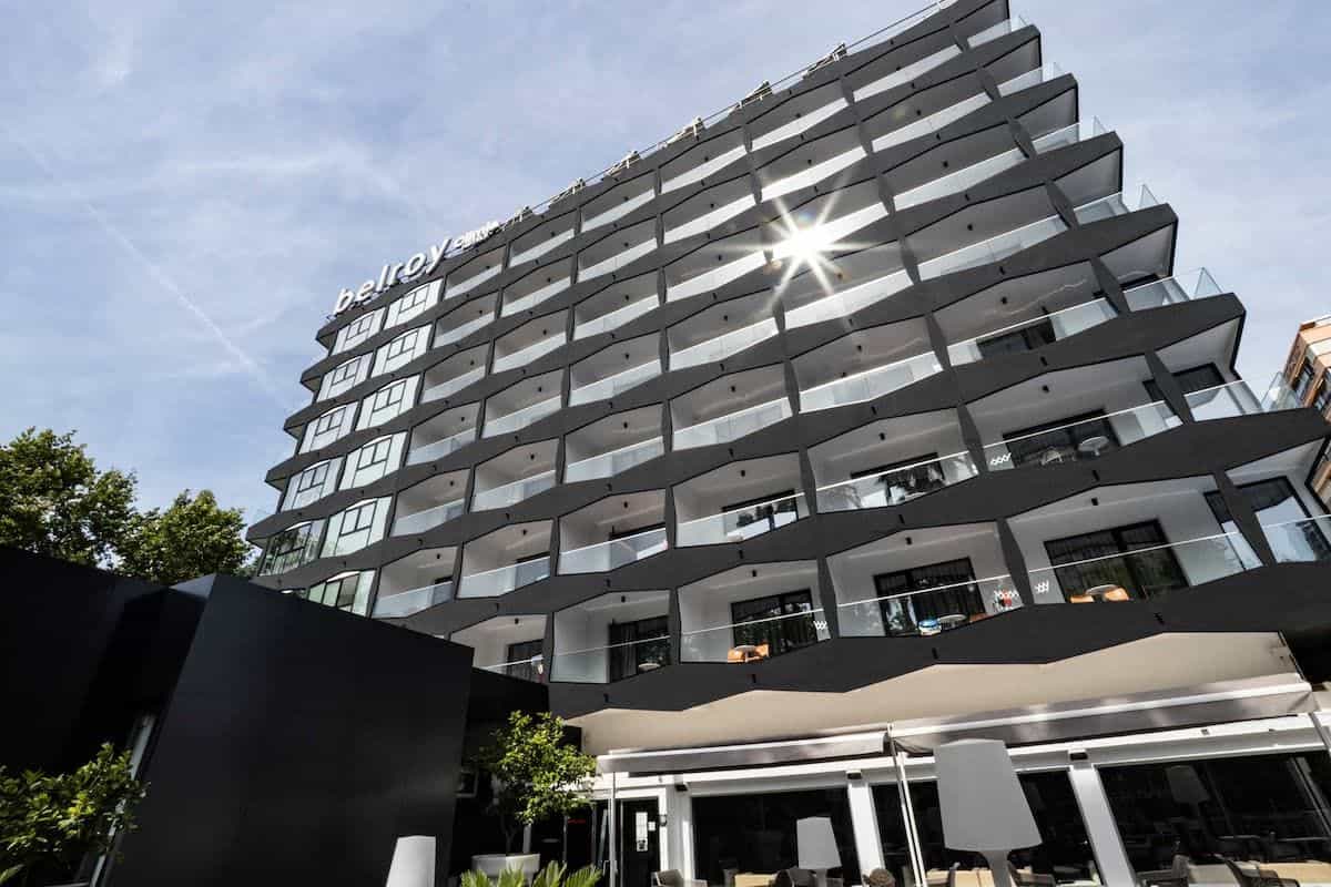 Hauptfassade des Hotels Climia Belroy in Benidorm: mehrstöckiges Gebäude mit Balkonen, Palmen im Vordergrund und weißem BELROY-Dachschild