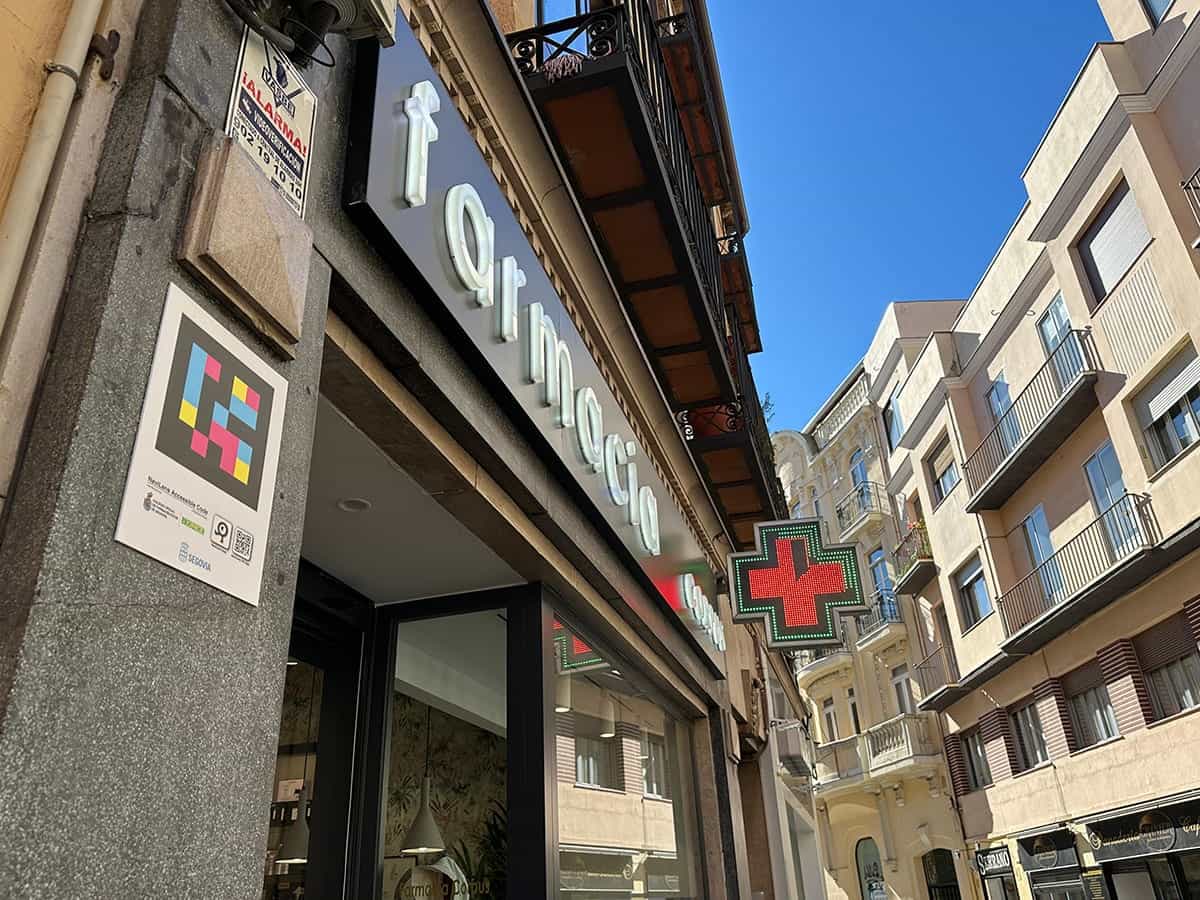 Farmacia del centro de Segovia con código NaviLens en la fachada junto a la cruz verde