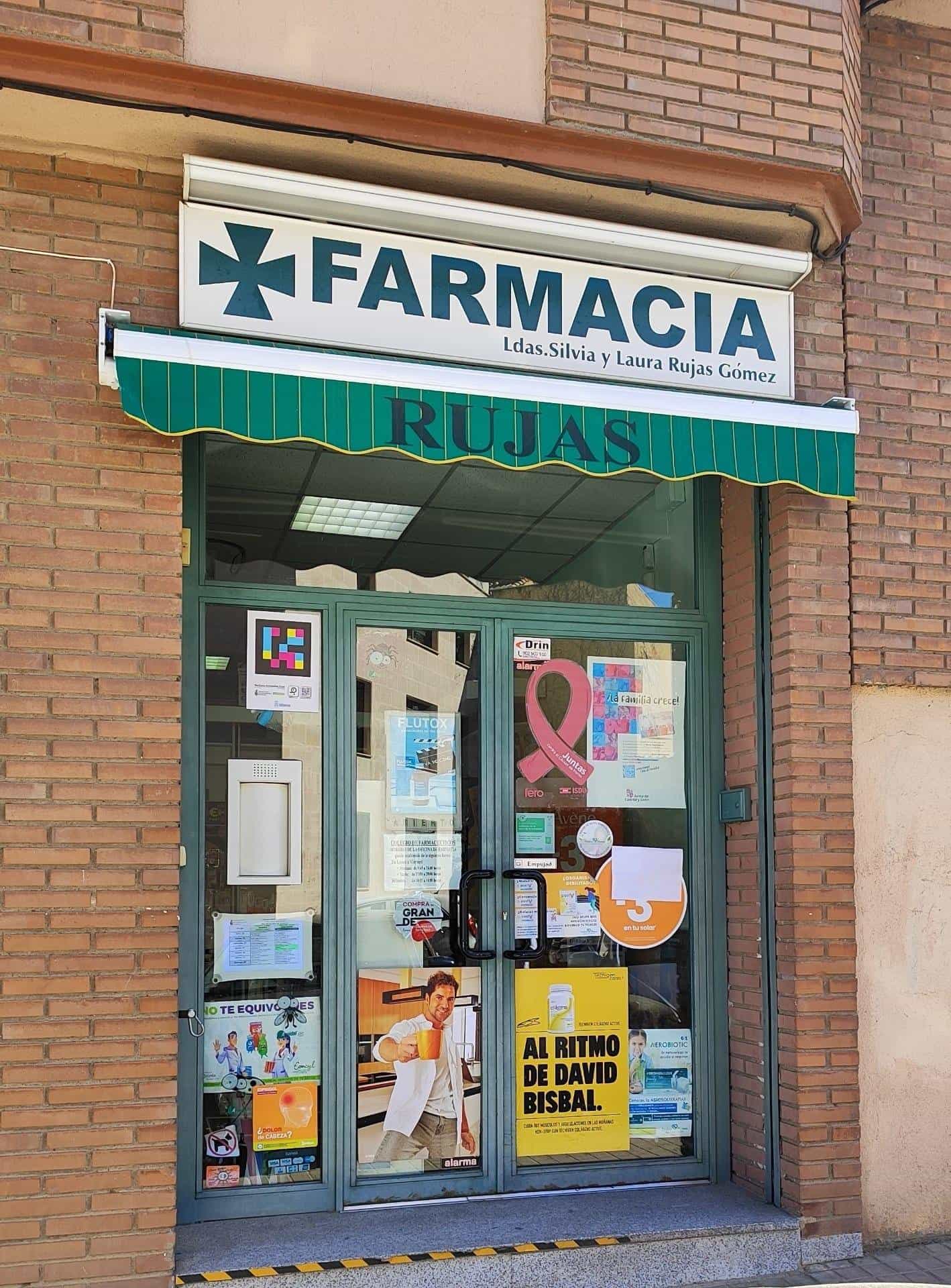 Facade of Farmacia Rujas in Segovia with the COF NaviLens sign placed on the glass door
