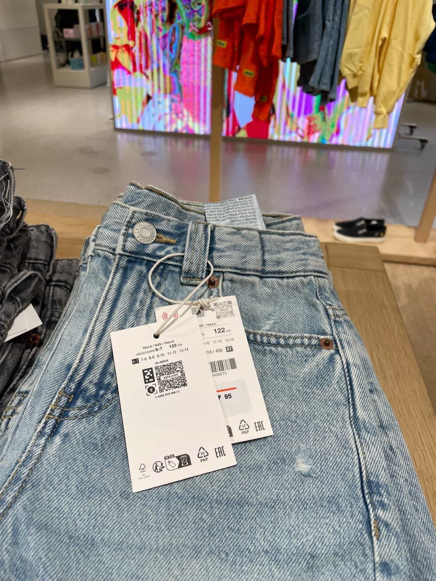 店内ディスプレイのジーンズに取り付けられたNaviLens下げ札のクローズアップ。