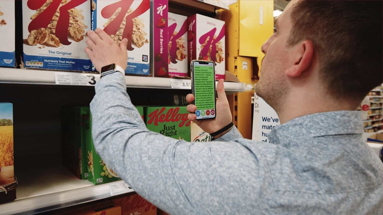 Shopper using the NaviLens app to identify a Kellogg's cereal box on a supermarket shelf.