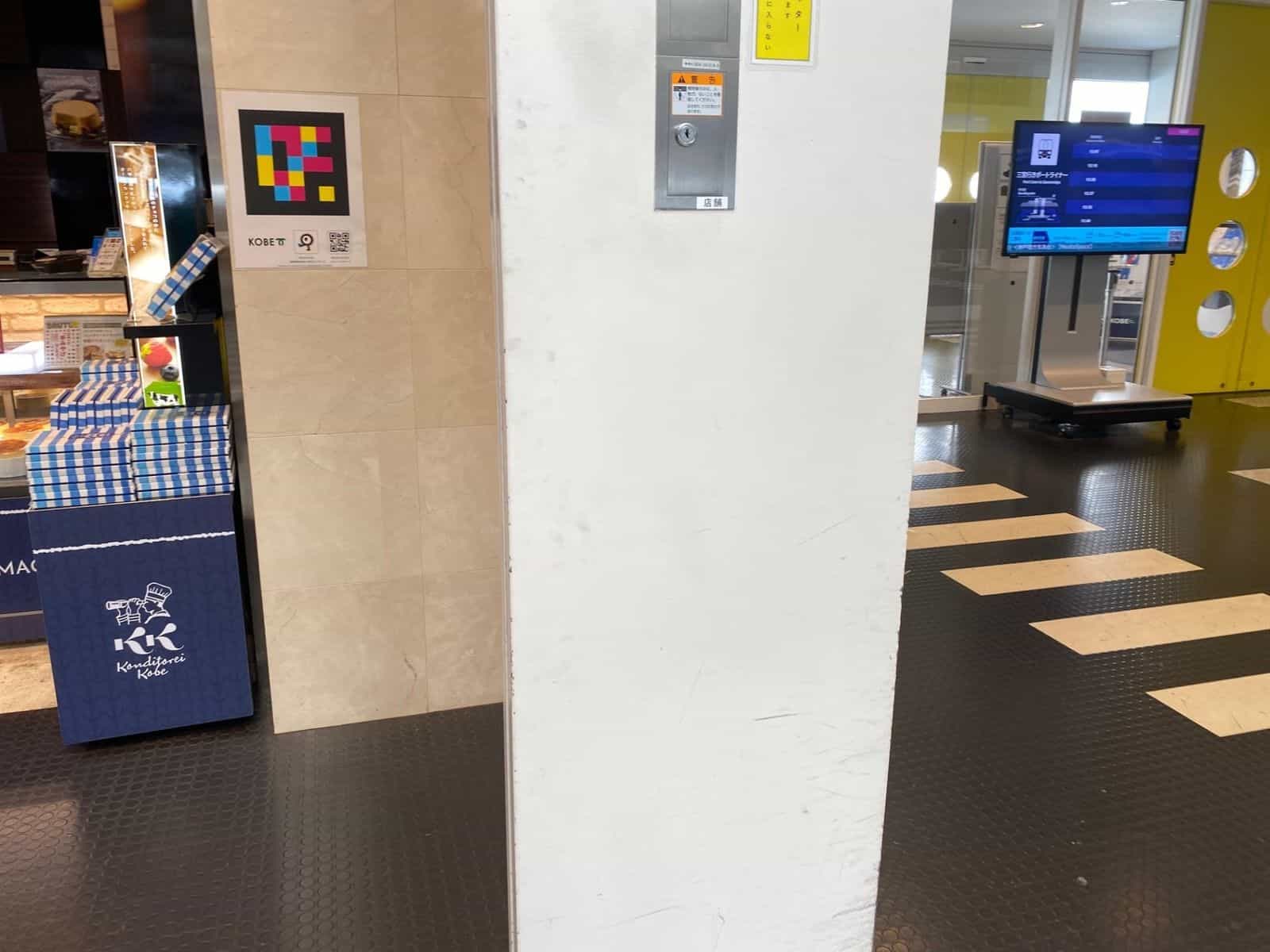 Souvenir-Shop Konditorei Kobe im Kobe Airport mit «KOBE»-Tafel, NaviLens-GO-Tag und QR zum App-Download