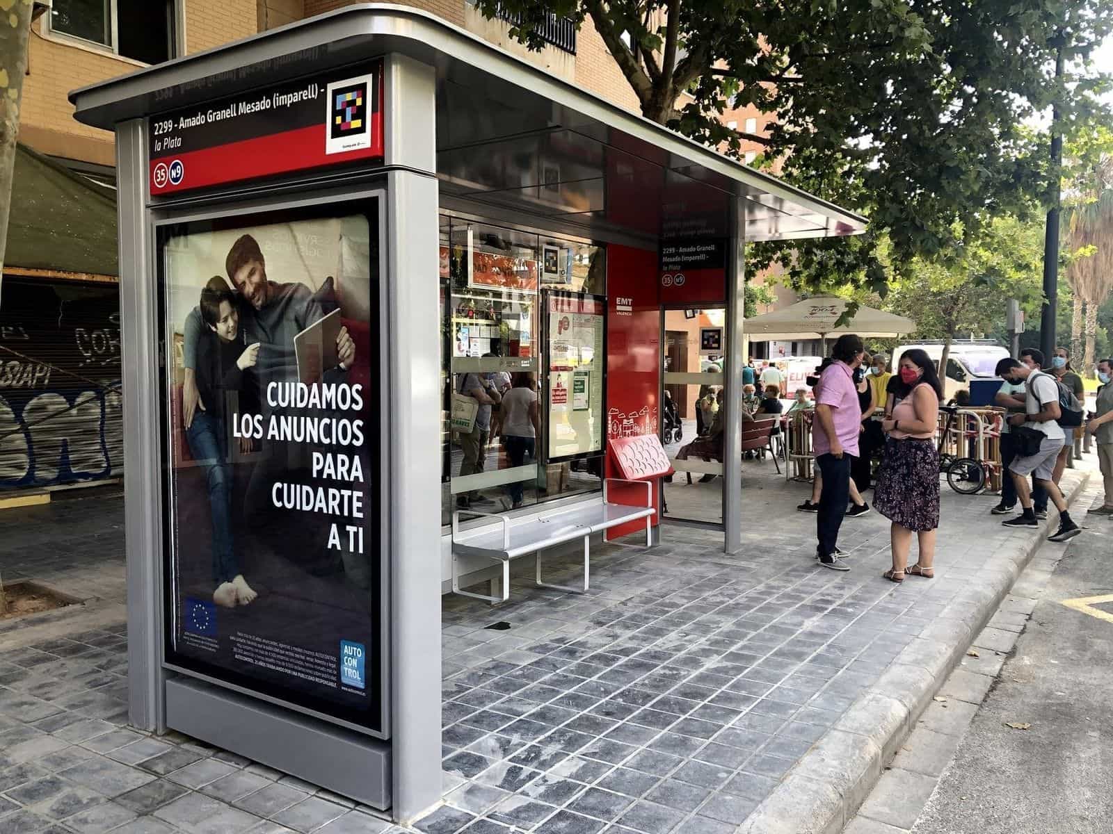 Veduta obliqua della pensilina della EMT València alla fermata 2299 «Amado Granell Mesado (imparell) – la Plata», linee 35 e N9; sul frontale del tetto, accanto alla targa numerica rossa, un codice NaviLens quadrato a colori chiaramente visibile dal marciapiede