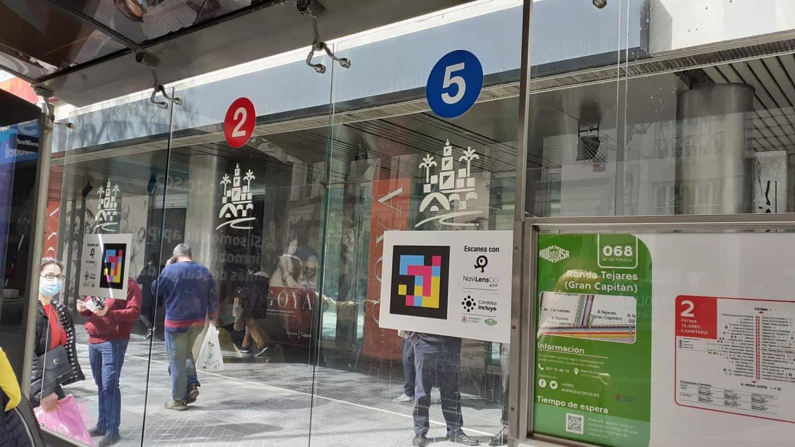 AUCORSA urban bus shelter on Ronda de Tejares (Córdoba): lines 2 and 5, NaviLens code next to the “Scan with NaviLensGO · Córdoba Incluye” sign
