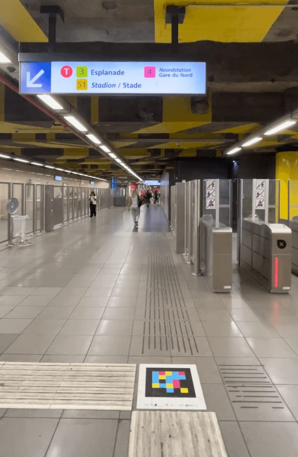 Brüsseler Metro-Umlauf mit Bahnsteig-Wegweiser und NaviLens-Code auf dem taktilen Streifen