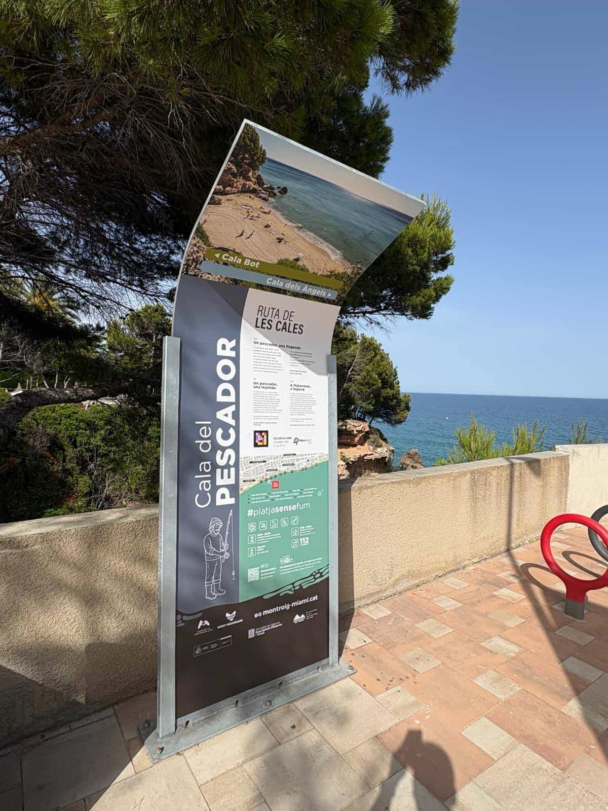Close-up of the Cala del Pescador panel: the title “RUTA DE LES CALES”, the story “Un pescador, una llegenda” repeated in Catalan, Spanish and English, and below it the NaviLens code next to the “ESCANEJA AMB · ESCANEA CON · SCAN WITH” label and the NaviLens GO logo
