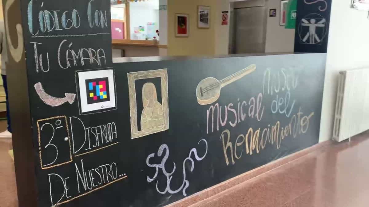 Panel general del museo musical del Renacimiento del IES Parque Goya: pared amarilla con los rótulos «Contexto», «Música Religiosa», «Música profana» y «Danza e Instrumentos», y filas de cuadros enmarcados con sus códigos NaviLens