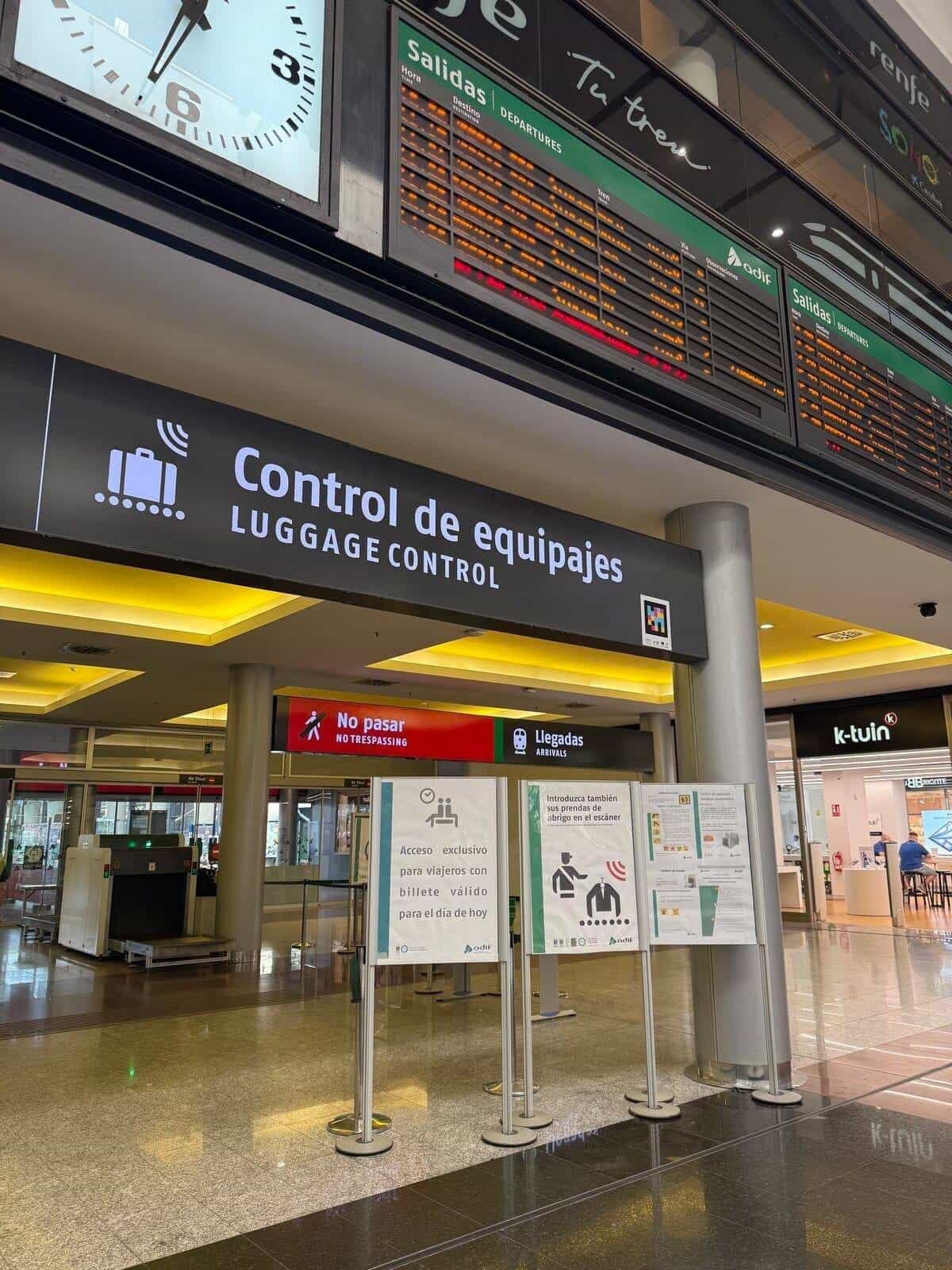 Málaga María Zambrano station with departure boards above security and a NaviLens marker next to the tactile floor guide